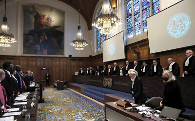 Judges and parties stand at the opening of the hearings at the International Court of Justice in The Hague, Netherlands, Thursday, Jan. 11, 2024. The United Nations' top court opened hearings Thursday into South Africa's allegation that Israel's war with Hamas amounts to genocide against Palestinians, a claim that Israel strongly denies. (AP Photo/Patrick Post)